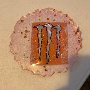Homemade pink monster resin coaster with gold flakes and white glitter.